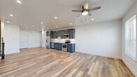 Located at 404 Industrial St in Denton, TX, this two-story home offers a thoughtfully designed layout spread across two floors. The main level features an open-concept kitchen and living area with light wood-look flooring that enhances the bright, airy atmosphere. The kitchen is outfitted with slate-blue shaker cabinetry, a white tile backsplash, and a full suite of stainless steel appliances including a refrigerator, dishwasher, microwave, and electric range. Recessed lighting and a ceiling fan complete the space, while multiple windows allow natural light to fill the living area. A classic staircase with dark wood railings connects the two floors. The upper level houses the bedrooms, including a spacious primary bedroom with its own private bathroom featuring wood-look tile flooring and a marble-tiled shower. The second bedroom offers plush carpet flooring and direct access to an exterior door. A third bathroom tucks neatly under the staircase, showcasing a clever use of space. Throughout the home, clean white walls, modern fixtures, and consistent finishes create a cohesive, contemporary aesthetic that is both functional and inviting.