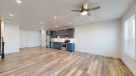 Located at 404 Industrial St in Denton, TX, this two-story home offers a thoughtfully designed layout spread across two floors. The main level features an open-concept kitchen and living area with light wood-look flooring that enhances the bright, airy atmosphere. The kitchen is outfitted with slate-blue shaker cabinetry, a white tile backsplash, and a full suite of stainless steel appliances including a refrigerator, dishwasher, microwave, and electric range. Recessed lighting and a ceiling fan complete the space, while multiple windows allow natural light to fill the living area. A classic staircase with dark wood railings connects the two floors. The upper level houses the bedrooms, including a spacious primary bedroom with its own private bathroom featuring wood-look tile flooring and a marble-tiled shower. The second bedroom offers plush carpet flooring and direct access to an exterior door. A third bathroom tucks neatly under the staircase, showcasing a clever use of space. Throughout the home, clean white walls, modern fixtures, and consistent finishes create a cohesive, contemporary aesthetic that is both functional and inviting.
