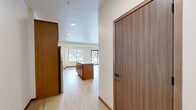 Located at 155 Gramsie Rd in Shoreview, MN, this two-bedroom, one-bathroom residence offers a thoughtfully designed single-floor layout. The open-concept kitchen and living area serves as the heart of the home, featuring warm medium-toned wood cabinetry, a central island with a light countertop, stainless steel appliances including a refrigerator, range, and dishwasher, and recessed lighting overhead. Light wood-style flooring flows throughout this main living area, creating a clean and cohesive aesthetic. The living area extends toward a sliding glass door that opens onto a private balcony, offering outdoor views and an abundance of natural light. Both bedrooms are carpeted and well-proportioned, with the primary bedroom offering generous closet space. A dedicated walk-in closet with wire shelving provides practical storage. The full bathroom features a tub-shower combination with clean white finishes and modern fixtures. Additional highlights include two hallways for smooth circulation, two closets, and a dedicated laundry area. The neutral color palette throughout — crisp white walls, warm wood tones, and light flooring — lends the space a bright, move-in-ready appeal well-suited for comfortable everyday living.