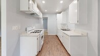 Located at 609 N Chippewa Ave in Anaheim, California, this single-floor residence offers a well-organized layout with distinct living, kitchen, sleeping, and bathroom areas. The open living and dining space features cool-toned gray walls, a mix of plush carpet and wood-style flooring, a ceiling fan, and a large picture window fitted with vertical blinds that invite natural light. A sliding glass door leads to an outdoor area, extending the living space and providing greenery views. The kitchen is designed for functionality, featuring white cabinetry with ample upper and lower storage, light granite-style countertops, recessed lighting, a gas range, a dishwasher, and a stainless steel sink — all set atop wood-style flooring that runs throughout. The bedroom is generously sized with soft carpeting, light blue-gray walls, and a door leading to the hallway. The bathroom is clean and bright, offering a full tub-shower combo, a white vanity with a quartz-style countertop, a large mirror, and wood-style flooring. Throughout the home, white trim and neutral tones create a cohesive, move-in-ready aesthetic well-suited to comfortable living in the heart of Anaheim.