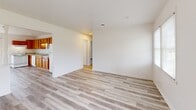 Located at 605 S Reilly Rd in Fayetteville, NC, this single-floor, 2-bedroom, 2-bathroom home offers a clean and functional layout designed for comfortable everyday living. Light gray wood-style flooring runs consistently throughout, lending a cohesive, modern feel to the entire space. The kitchen is equipped with warm honey-toned cabinetry, a double-basin sink, and white appliances including a refrigerator, electric range, and dishwasher. A charming half-wall with decorative white spindles visually separates the kitchen from the open living area, while a sliding glass door floods the space with natural light and provides direct access to the outdoors. The living room is generously sized and open, connecting seamlessly to the kitchen for a practical, flowing floor plan. The primary bedroom offers ample space and includes closet access, while the second bedroom features a window for natural light. A dedicated laundry area with built-in shelving and washer/dryer hookups adds convenience. Both bathrooms and all rooms are finished with crisp white walls, creating a bright and neutral interior that is move-in ready and easy to personalize.