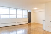 Located on the 15th floor at 1465 Lawrence Ave W in Toronto's Lawrence Heights neighbourhood, this one-bedroom, one-bathroom unit offers a well-organized layout across a single floor. The open-concept living and dining area is defined by classic parquet hardwood flooring and a wall of large floor-to-ceiling windows that flood the space with natural light and frame expansive city views. Baseboard heating units run along the window wall, ensuring year-round comfort.

The kitchen is thoughtfully designed with white cabinetry, a herringbone tile backsplash, dark countertops, and stainless steel appliances including a full-sized French door refrigerator, stove, and microwave. A peninsula with a raised countertop creates a natural division between the kitchen and living area while providing additional workspace.

The bedroom is a comfortable size, featuring the same warm parquet flooring, a window with outdoor views, and full-width mirrored sliding closet doors that add depth and reflect light throughout the room.

The bathroom is finished with crisp white subway tiles from floor to ceiling, a soaking tub with an adjustable shower fixture, and a mirrored vanity, creating a clean and functional space. The unit's elevated position, abundant natural light, and city views make it a practical and appealing urban residence.