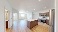 This well-designed 2-bedroom, 3-bathroom single-floor unit offers a clean, contemporary aesthetic with a practical, efficient layout. The open-concept kitchen and living area serves as the heart of the space, featuring light hardwood flooring that extends throughout. The kitchen is equipped with a full suite of stainless steel appliances, including a range, microwave, dishwasher, and refrigerator. Rich walnut-toned cabinetry lines the walls, complemented by a large central island with a white quartz countertop, providing ample workspace and casual seating. Recessed lighting illuminates the area, enhancing the bright, airy atmosphere created by natural light flowing in from multiple windows.

Both bedrooms are comfortably sized with large windows that offer outdoor views of the surrounding neighborhood. The primary bedroom includes a dedicated closet with built-in hanging storage. Each bedroom benefits from individual climate control. The three bathrooms are finished in a consistent modern style, featuring walnut-toned vanities with white countertops, tub-shower combinations with white tile surrounds, and chrome fixtures. A hallway connects all rooms, contributing to a smooth and logical flow throughout the unit.
