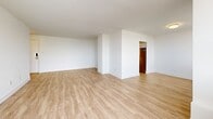 Located at 1350 Danforth Road in Toronto's Scarborough district, this well-appointed 3-bedroom, 2-bathroom unit offers a generous and functional layout across a single floor. Light-toned hardwood flooring flows throughout the unit, complementing the clean white walls and creating a bright, airy atmosphere.

The open living area is bathed in natural light from large windows, with a baseboard heating system integrated seamlessly along the walls. A sliding glass door leads to a private balcony enclosed by sleek glass railings, offering expansive views of the surrounding Toronto skyline and neighbouring residential towers.

The kitchen is thoughtfully designed with white shaker-style cabinetry, grey countertops, a white subway tile backsplash, and a full suite of stainless steel appliances including a refrigerator, electric range, over-the-range microwave, and dishwasher.

The primary bedroom is generously sized, featuring wide windows that invite natural light. The two additional bedrooms are well-proportioned with large windows and ample wall space. Two bathrooms serve the unit — one featuring a soaker tub with full white subway tile surround and a window, and the other with a clean, minimalist design. A dedicated closet and entry hallway complete this practical and comfortable home.