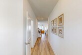 Located on Canopy Circle in Hixson, Tennessee, this well-appointed two-story home offers four bedrooms, three bathrooms, and a thoughtfully designed layout spread across two floors. The main level is the larger of the two, housing the open-concept living, dining, and kitchen area — a bright, welcoming space anchored by light hardwood-style flooring and recessed lighting. The kitchen stands out with gray shaker cabinets, white quartz countertops, a subway tile backsplash, stainless steel appliances, and an adjacent pantry for added storage. A ceiling fan and large windows bring natural light into the living area, which flows seamlessly into the dining space. The main floor also includes a garage, laundry room, and hallway access to additional rooms. The primary bedroom is a generously sized retreat featuring a tray ceiling, ceiling fan, plush carpet, and natural light from large windows. Its en-suite bathroom includes a dual-sink vanity with quartz counters, stylish cabinetry, and a tiled walk-in shower. Upstairs, the second floor provides additional bedrooms — each carpeted and closet-equipped — along with a bedroom that overlooks the staircase landing via a charming wood-railed balcony. Throughout the home, clean white walls, consistent finishes, and five closets ensure both style and practicality.