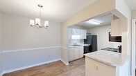 Located at 1701 37th Street in Phenix City, Alabama, this one-bedroom, two-bathroom residence offers a practical and well-organized single-floor layout. The kitchen is equipped with white cabinetry, granite-style countertops, a tile backsplash, black appliances including a refrigerator, dishwasher, electric range, and microwave, and a peninsula that opens to the adjacent dining area. The dining room features warm wood-look flooring and an elegant chandelier overhead, creating a welcoming atmosphere for meals. The living room is finished with plush carpeting, a ceiling fan with light fixture, and a sliding glass door that lets in natural light and provides outdoor access. The bedroom is comfortably sized with soft carpeting, a ceiling fan, and its own access to the hallway. A dedicated closet provides convenient storage. The two bathrooms include a full bath with a vanity featuring granite-style countertops, a large mirror, and a tub-shower combination, complemented by wood-look flooring throughout. Textured ceilings are consistent across the home, adding a classic touch. The neutral color palette and clean finishes give the space a bright, move-in-ready feel.