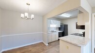 Located at 1701 37th Street in Phenix City, Alabama, this one-bedroom, two-bathroom residence offers a practical and well-organized single-floor layout. The kitchen is equipped with white cabinetry, granite-style countertops, a tile backsplash, black appliances including a refrigerator, dishwasher, electric range, and microwave, and a peninsula that opens to the adjacent dining area. The dining room features warm wood-look flooring and an elegant chandelier overhead, creating a welcoming atmosphere for meals. The living room is finished with plush carpeting, a ceiling fan with light fixture, and a sliding glass door that lets in natural light and provides outdoor access. The bedroom is comfortably sized with soft carpeting, a ceiling fan, and its own access to the hallway. A dedicated closet provides convenient storage. The two bathrooms include a full bath with a vanity featuring granite-style countertops, a large mirror, and a tub-shower combination, complemented by wood-look flooring throughout. Textured ceilings are consistent across the home, adding a classic touch. The neutral color palette and clean finishes give the space a bright, move-in-ready feel.