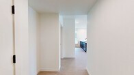 This well-appointed 2-bedroom, 2-bathroom apartment on the fifth floor at 440 W Columbia Way offers a clean, contemporary aesthetic throughout. Light wood-tone flooring flows seamlessly across the single-level layout, complementing the crisp white walls and modern finishes found in every room.

The open-concept kitchen and living area serves as the heart of the home. The kitchen is outfitted with dark shaker-style cabinetry, a white subway tile backsplash, stainless steel appliances including a gas range and refrigerator, and a peninsula with a quartz countertop and undermount sink — ideal for both cooking and casual dining. The adjoining living area is bathed in natural light through large floor-to-ceiling windows, with a door opening to a private balcony that offers sweeping outdoor views of the waterfront and surrounding cityscape.

The primary bedroom is generously sized and features large windows with exterior views, while the second bedroom also benefits from natural light and a clean, open feel. Each bedroom is served by its own dedicated closet. Both bathrooms are finished with light flooring, dark hardware accents, and vanities with ample storage. One bathroom features a full soaking tub with a tiled surround, while the other is designed with accessibility in mind. Hallways connect the spaces efficiently, completing this thoughtfully designed urban residence.