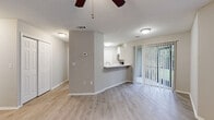 This 2-bedroom, 2-bathroom apartment at Agora Apartments in Port Richey, Florida offers a practical and comfortable single-floor layout. Light wood-style flooring flows throughout the main living areas and bedrooms, complemented by neutral gray and white walls that create a clean, bright atmosphere. Ceiling fans are installed in the living room and both bedrooms, enhancing comfort year-round.

The open-concept living and dining area connects seamlessly to the kitchen via a peninsula counter with a stone-look surface, ideal for casual dining or food preparation. The kitchen is equipped with white cabinetry, stainless steel appliances including a dishwasher and microwave, a black refrigerator, and a stainless sink beneath a window with vertical blinds that allow natural light.

Both bedrooms are well-sized, with the primary bedroom offering generous closet space via double sliding doors. Each bedroom features windows overlooking greenery. The two full bathrooms are finished in white, each including a tub-shower combination, toilet, and vanity with wood-style flooring. Additional features include six closets throughout, a dedicated laundry area, utility room, entrance foyer, and a private patio, providing excellent storage and functional living space.