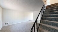 Located at 5200 SW 141st Ave in Beaverton, Oregon, this two-story apartment offers three bedrooms and two bathrooms thoughtfully distributed across two floors. The main level provides a well-appointed kitchen featuring white cabinetry, granite-style countertops, a center island with a cooktop, stainless steel dishwasher, and a black refrigerator, all set on wood-look flooring. A pantry closet and a window allowing natural light complete the kitchen space.

The bedrooms are carpeted and feature ceiling fans with light fixtures, adding comfort and functionality. Each bedroom includes sliding or bifold closet doors providing generous storage. Windows with vertical blinds invite natural light and offer views of the surrounding greenery. Baseboard heaters ensure warmth throughout the cooler months.

The bathrooms are clean and practical, with one featuring a granite-topped vanity with white cabinetry and mirror, and another equipped with a full tub-shower combination framed by white tile and a frosted privacy window. Textured ceilings are consistent throughout the unit. A hallway connects the living areas, and the overall color palette of whites and neutral tones gives the space a bright, clean ambiance well-suited for comfortable everyday living.