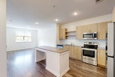 Located at 15151 Mattawoman Dr in Brandywine, MD, this well-appointed single-floor residence offers a thoughtfully designed layout that maximizes comfort and functionality. The open-concept living area seamlessly integrates the kitchen, dining, and living spaces, creating a bright and connected atmosphere. The modern kitchen is equipped with stainless steel appliances, including a range, microwave, and dishwasher, complemented by light wood cabinetry, a subway tile backsplash, and a granite-topped island that doubles as a breakfast bar. Wood-style plank flooring flows consistently throughout the entire unit, adding warmth and cohesion to the design. Recessed lighting illuminates the main living area, which features a window that invites natural light and outdoor views. The bedroom is a generously sized, bright retreat with a large window overlooking greenery, and connects directly to the full bathroom. The bathroom is finished with a granite-topped vanity, light wood cabinetry, a mirror, and modern hardware. The unit includes four closets — one of which is a spacious walk-in with wire shelving — providing exceptional storage. A dedicated laundry area adds everyday convenience, rounding out this clean, contemporary residence.