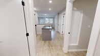 Located on Skyview Parade NE in Calgary, AB, this 2-bedroom, 1-bathroom unit offers a well-designed, single-floor layout with modern finishes throughout. Light wood-look flooring flows consistently across every room, creating a cohesive and clean aesthetic.

The kitchen serves as the focal point of the main living area, featuring an open-concept design anchored by a peninsula with a dark granite countertop and integrated sink. Grey cabinetry extends to the ceiling, paired with a full suite of stainless steel appliances including a bottom-freezer refrigerator, electric range, and over-the-range microwave. Recessed lighting illuminates the space efficiently.

Both bedrooms are neutrally toned with soft grey walls, baseboard heating, and light wood flooring. The primary bedroom benefits from a large window that brings in natural light and offers views of the surrounding neighbourhood. The second bedroom is a compact, versatile space suitable for various uses.

The bathroom is well-appointed with grey cabinetry, a dark countertop vanity with mirror, a tub-shower combination, and a conveniently integrated stacked washer and dryer unit — a practical feature that maximizes functionality within the space.

Two hallways connect the rooms efficiently, contributing to a logical and easy-to-navigate floor plan throughout this tidy, contemporary unit.
