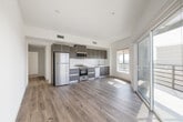 Located at 5801 W Pico Blvd in the heart of Los Angeles, Unit 603 is a thoughtfully designed modern residence finished with clean, contemporary details throughout. Wide-plank wood-style flooring runs continuously across the open living areas, complementing the bright white walls and recessed lighting that give each room an airy, well-lit feel.

The living area is generously proportioned and anchored by a large sliding glass door that opens to a private balcony, offering sweeping views of the Los Angeles cityscape — a standout feature of the space. A second room also enjoys direct balcony access, further enhancing the connection to the outdoors and natural light.

The kitchen is outfitted with two-tone cabinetry in warm taupe and cool grey tones, stainless steel appliances including a refrigerator, gas range, microwave, and dishwasher, along with a white tile backsplash and light countertops that tie the space together cleanly.

The bedrooms are well-sized, with one featuring a built-in closet system with shelving and drawers for ample storage. Both bathrooms are finished with large-format beige tile flooring and tile-surround tub-shower combinations with sliding glass doors and modern fixtures. A dedicated in-unit laundry closet with a stacked washer and dryer adds everyday convenience to this polished Los Angeles residence.