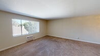 Located at 9585 Gold Coast Dr in San Diego, this single-floor unit offers a practical and well-organized layout. The living area is generously sized, featuring warm neutral-toned walls, plush carpeting, and a large window dressed with vertical blinds that allows natural light to filter in while offering views of the surrounding greenery. A wall-mounted HVAC unit provides individual climate control.

The kitchen is efficiently designed with warm wood-toned cabinetry lining both walls, granite-look countertops, a double stainless steel sink, and hardwood-style flooring. White appliances — including a refrigerator, electric range, and over-the-range microwave — are neatly integrated, and a window above the counter adds additional natural light. A breakfast bar counter opens toward the carpeted living and entry area, creating a connected, open feel.

The bedroom is a comfortable, well-lit space with plush carpeting, neutral walls, a window with vertical blinds, and a sliding closet for ample storage.

The bathroom features tile flooring, a vanity with granite-look countertops and wood cabinetry, a wall-mounted mirror, and a full tub-shower combination with a window above for ventilation. The overall ambiance throughout is clean, neutral, and move-in ready.