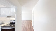 This 860 square foot apartment in Summit West offers a well-designed living space with two bedrooms and one bathroom. The unit features a modern, open-concept kitchen and living area, showcasing white cabinetry, stainless steel appliances, and a practical layout. The kitchen is equipped with ample storage, a full-size refrigerator, dishwasher, and electric range.

Throughout the apartment, warm wood flooring adds a touch of elegance and continuity. The primary bedroom, measuring 160 square feet, provides a cozy retreat with a built-in closet. The second bedroom, while slightly smaller, also includes storage space. The bathroom is efficiently designed with a shower/tub combination and clean, white tiling.

Natural light floods the space through windows in each room, including vertical blinds in the living area for light control. A ceiling fan in the main living space aids in air circulation. The apartment also features a dedicated laundry area and additional closet space in the hallway, maximizing storage options.

The neutral color palette of white walls and ceilings creates a bright, airy atmosphere that allows for personalization. This Summit West apartment combines functionality with modern touches, offering a comfortable living environment in a compact, well-utilized space.