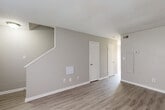 Located at 812 Fairview Dr in Lexington, NC, this two-story home offers a practical and well-organized layout spread across two floors. The main level features a living room with light-toned luxury vinyl plank flooring, neutral gray walls, and a textured ceiling, creating a clean and understated aesthetic. The kitchen is well-equipped with warm oak cabinetry, light countertops, black appliances including an electric range and dishwasher, a stainless steel sink, and matching LVP flooring that ties the space together. An adjacent dining area and a utility room round out the ground floor, which also includes a staircase connecting to the upper level. Upstairs, the two bedrooms are finished with plush carpet and ceiling fans, providing a comfortable and cozy atmosphere. The primary bedroom is generously sized and benefits from natural light through a window. Both bedrooms feature closet access, and the floor plan includes a total of four closets throughout the home for ample storage. The two bathrooms are finished with clean white fixtures, including a full tub-shower combination with chrome hardware. Textured ceilings are consistent throughout, and the neutral color palette gives the entire home a bright, move-in-ready feel.