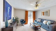 Located at 1108 Saint Andrews Dr in Wilmington, NC, this single-floor residence offers three bedrooms, two bathrooms, and a practical, efficiently designed layout. The living room serves as the heart of the home, featuring plush carpeting, a ceiling fan with light fixture, and a sliding glass door framed by warm orange drapes that invite natural light and outdoor access. The space flows seamlessly into the dining area, where wood-look flooring and a glass-top table create an elegant transition into the kitchen. The kitchen is outfitted with dark espresso cabinetry, granite-style countertops, a full suite of appliances, and ample storage — a functional and stylish cooking space. The three bedrooms are carpeted and filled with natural light from well-positioned windows dressed with blinds and curtains. The primary bedroom offers a comfortable footprint with room for a full furniture arrangement. The two bathrooms are finished with dark wood vanities, white countertops, framed mirrors, and tub-shower combinations with wood-look flooring. A hallway and closet complete the layout, adding to the home's practical storage and circulation. Textured ceilings are consistent throughout, contributing to the cohesive character of this well-maintained Wilmington residence.