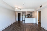 Located at 1500 Parkwood Cir SE in Atlanta, Georgia, this single-floor residence offers a thoughtfully designed layout with modern finishes throughout. The open-concept living and dining area is anchored by warm wood-style plank flooring, neutral-toned walls, and large windows fitted with blinds that invite natural light while framing views of surrounding greenery. A tray ceiling with integrated track lighting adds architectural interest to the main living space.

The kitchen is well-equipped with stainless steel appliances, including an electric range and over-the-range microwave, complemented by granite countertops, grey shaker-style cabinetry, and a classic subway tile backsplash. Pendant lighting above the counter peninsula enhances both function and style.

The bedrooms continue the wood-style flooring and feature ample natural light through generously sized windows. Dark-paneled doors provide a bold contrast against the crisp white walls throughout the unit.

The bathrooms are finished with large-format tile flooring, granite-topped grey vanities, and well-lit mirrors. One bathroom features a tub-shower combination with full tile surround, while another offers an expanded vanity layout. Together, these spaces deliver a clean, contemporary aesthetic well-suited to modern living in the Atlanta metro area.