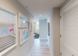 Located at 405 NE 2nd Street in the heart of Fort Lauderdale, FL, this modern single-floor residence offers a thoughtfully designed layout with contemporary finishes throughout. A welcoming hallway sets the tone, featuring light wood-style flooring, recessed lighting, louvered closet doors, and colorful framed artwork that adds a vibrant coastal character to the entry.

The kitchen is outfitted with sleek flat-front cabinetry in a light natural finish, stainless steel appliances including a French door refrigerator, range, and built-in microwave, complemented by a textured tile backsplash and clean white countertops.

The living area is bright and airy, anchored by floor-to-ceiling sliding glass doors that open to a private balcony overlooking lush greenery. Sheer white curtains frame the expansive windows, allowing abundant natural light to fill the space.

Two well-proportioned bedrooms offer comfort and natural light, each with light flooring and generous window placement. The primary bathroom features a glass-enclosed walk-in shower, a floating vanity, and refined tile work, while the secondary bathroom includes a full soaking tub with tiled surround. The overall aesthetic is clean, contemporary, and cohesive throughout.