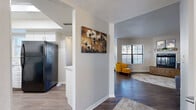 Located at 2600 W Ina Rd in Tucson, Arizona, this single-story residence offers a well-designed, functional layout across a comfortable and cohesive floor plan. The interior features a combination of wood-look flooring in the main living areas and plush carpet in the bedroom and office spaces, creating distinct zones throughout the home.

The kitchen is outfitted with white cabinetry, light quartz-style countertops, and black appliances including a refrigerator, dishwasher, and stovetop, all set against easy-to-maintain hard flooring. Adjacent to the kitchen, the hallway opens into a bright living room featuring a fireplace, a mirrored wall accent, and natural light from large windows fitted with blinds.

The dining area accommodates intimate gatherings beneath a ceiling fan, while a secondary sitting or flex space provides additional room for relaxation or work. A dedicated home office nook with a wall-mounted desk and shelving offers a practical workspace with a window view.

The bedroom is generously proportioned with carpet flooring, a large window allowing ample natural light, and easy access to the bathroom. The bathroom features white shaker-style cabinetry, a granite-look countertop, a mirrored medicine cabinet, and a built-in linen closet for added storage. The overall ambiance is clean, neutral, and move-in ready.