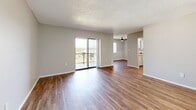 Located at 840 S Grand Hwy in Clermont, FL, this well-appointed 2-bedroom, 2-bathroom single-floor residence offers a practical and comfortable layout. The living area welcomes you with durable wood-look flooring, neutral gray walls, and a textured ceiling, creating a clean and inviting atmosphere. A ceiling fan adds comfort, while sliding glass doors lead to a private balcony that fills the space with natural light and offers pleasant outdoor views of the surrounding landscape.

The kitchen is positioned conveniently off the main living area, offering easy accessibility throughout the home. Both bedrooms feature soft, plush carpeting and dedicated closets with built-in shelving, providing ample storage. The primary bedroom is generously sized and includes direct access to its own bathroom, enhancing privacy and convenience. Natural light filters through vertical-blind-covered windows in each bedroom, contributing to a bright and airy feel.

The two bathrooms are finished in a clean, classic style, each featuring a full tub-shower combination, white vanity with countertop, and mirror. Wood-look flooring in the bathrooms complements the overall design continuity of the home. Two hallways connect the rooms efficiently, and the layout, as seen in the dollhouse view, is thoughtfully organized for comfortable everyday living.