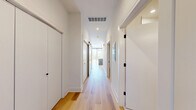Located in Chicago's vibrant West Loop neighborhood, this modern one-bedroom, one-bathroom unit at 224 S Ashland Ave offers a well-designed layout spread across a single floor. Light-toned hardwood flooring flows consistently throughout, lending warmth and cohesion to every room.

The open-concept kitchen and living area serves as the heart of the unit. The kitchen is outfitted with contemporary flat-front cabinetry in a warm wood-grain finish, white quartz countertops, a subway tile backsplash, and a full suite of stainless steel appliances including a gas range, built-in microwave, dishwasher, and refrigerator. A central island with pendant globe lighting provides additional prep space and a natural gathering point.

The bedroom is a generously sized retreat featuring a ceiling fan and a large window with striking views of the Chicago skyline, allowing abundant natural light to pour in. A dedicated walk-in closet with built-in shelving and double hanging rods offers practical, well-organized storage.

The bathroom maintains the unit's clean aesthetic with light tile flooring, a wood-toned vanity, and matte black hardware accents that echo the modern design language found throughout. The overall ambiance is crisp, contemporary, and move-in ready.