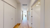 Located in Chicago's vibrant West Loop neighborhood, this modern one-bedroom, one-bathroom unit at 224 S Ashland Ave offers a well-designed layout spread across a single floor. Light-toned hardwood flooring flows consistently throughout, lending warmth and cohesion to every room.

The open-concept kitchen and living area serves as the heart of the unit. The kitchen is outfitted with contemporary flat-front cabinetry in a warm wood-grain finish, white quartz countertops, a subway tile backsplash, and a full suite of stainless steel appliances including a gas range, built-in microwave, dishwasher, and refrigerator. A central island with pendant globe lighting provides additional prep space and a natural gathering point.

The bedroom is a generously sized retreat featuring a ceiling fan and a large window with striking views of the Chicago skyline, allowing abundant natural light to pour in. A dedicated walk-in closet with built-in shelving and double hanging rods offers practical, well-organized storage.

The bathroom maintains the unit's clean aesthetic with light tile flooring, a wood-toned vanity, and matte black hardware accents that echo the modern design language found throughout. The overall ambiance is crisp, contemporary, and move-in ready.
