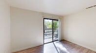 Located at 6430 Verner Avenue in Sacramento, California, this one-bedroom, one-bathroom unit offers a well-organized single-floor layout designed for comfortable everyday living. The living area is bright and airy, featuring light wood-look laminate flooring and a large sliding glass door that opens onto a private balcony with outdoor views of surrounding greenery, allowing natural light to fill the space throughout the day. A dedicated entry door provides direct access from the living area. The kitchen is efficiently laid out in a U-shape configuration, equipped with white cabinetry offering generous storage, a refrigerator, electric range, built-in microwave, and a sink — all finished with matching light wood-look flooring that ties the space together. The bedroom features soft wall-to-wall carpeting, a large window fitted with vertical blinds that invite natural light, and a closet accessible through a classic six-panel door. The full bathroom is well-appointed with a vanity featuring white cabinetry and a large mirror, a combination shower and bathtub, and the same wood-look flooring found throughout the main living areas. Neutral wall tones throughout the unit create a clean, versatile backdrop well-suited for a variety of interior styles.