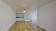 This thoughtfully designed 1-bedroom, 1-bathroom residence offers a clean, modern aesthetic across a single floor. Light wood flooring flows seamlessly throughout the entire space, creating a cohesive and airy feel. The entrance opens into a bright, open-concept living and dining area illuminated by a ceiling fan with integrated lighting and large windows dressed with vertical and horizontal blinds that invite natural light. The kitchen is well-equipped with white shaker cabinetry, granite countertops, stainless steel appliances including a full-size refrigerator, a built-in dishwasher, a range hood, and a peninsula that provides additional workspace and casual seating. The bedroom is a comfortable, well-proportioned retreat featuring a ceiling fan with light, a sizeable window with blinds, and a dedicated HVAC vent for climate control. The bathroom offers a clean, functional layout with a granite-topped vanity, white cabinetry, a large mirror, and a full shower-tub combination. Clean white walls and consistent finishes throughout the space contribute to a bright and welcoming atmosphere.