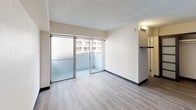 Located at 441 Walina St in the heart of Honolulu's Waikiki neighborhood, this single-floor unit combines modern updates with a clean, functional layout. The open living area is anchored by light-toned wood-style flooring that flows throughout the space, complemented by neutral walls and a textured ceiling. Sliding glass doors lead to a private balcony, allowing natural light to fill the room and offering views of the surrounding neighborhood.

The kitchen is well-appointed with rich, dark-stained wood cabinetry, light granite countertops, and a full suite of stainless steel appliances including a refrigerator, built-in cooktop, over-the-range microwave, and dishwasher. The layout is efficient and provides ample storage and prep space.

The bathroom showcases a refined design with large-format beige tile walls accented by a decorative band of natural stone mosaic tiling at mid-height, creating a polished, spa-like aesthetic. A frameless glass shower enclosure adds to the clean, contemporary feel.

Additional features include a closet near the entry, consistent flooring throughout, and a thoughtful use of space that maximizes comfort and livability. This unit offers a well-finished, move-in-ready option in one of Honolulu's most sought-after locations.