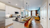 This single-floor residence offers a thoughtfully designed layout across two bedrooms and two bathrooms. The open-concept kitchen is a standout feature, equipped with stainless steel appliances, crisp white shaker cabinetry, dark countertops, and a large island with bar seating, illuminated by pendant lighting overhead. The kitchen flows seamlessly into the living and dining areas, creating a cohesive, sociable space. Natural light enters through generously sized windows dressed with blinds and curtain panels. The living area features warm hardwood-style flooring found throughout the main areas, complemented by a bold accent wall that adds character and depth.

The primary bedroom is a comfortable, well-proportioned retreat with a window, hardwood-style flooring, and access to a dedicated closet with built-in wire shelving. The second bedroom offers similar finishes and natural light. Each bathroom is finished with a dark countertop vanity, white cabinetry, and modern fixtures. One bathroom provides direct access to a closet, adding functional convenience. Two hallways connect the rooms efficiently. The overall ambiance is modern and inviting, blending contemporary finishes with warm, livable design throughout.