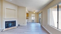 Located at 2130 S Santa Fe Ave in Vista, CA, this 2-bedroom, 1-bathroom home offers a well-organized, comfortable layout with consistent light wood-style flooring and warm neutral tones throughout. The open living room is a standout space, featuring a ceiling fan, a wood-burning fireplace with a classic white surround, and a sliding glass door that opens to a private balcony with scenic views of the surrounding hills and neighborhood. Large windows flood the room with natural light and frame pleasant outdoor vistas. Adjacent to the living area, the galley-style kitchen is efficiently designed with warm wood cabinetry, dark granite-style countertops, and white appliances including a gas range, refrigerator, and dishwasher. A utility area off the living room conveniently houses an in-unit washer and dryer. Both bedrooms are bright and well-proportioned, each with windows that bring in natural light and views of the greenery outside. The primary bedroom includes access to two closets, one of which is a dedicated walk-in with built-in shelving and hanging rods. The bathroom features a wide vanity with light wood cabinetry, a large mirror, and a separate shower area. Textured ceilings are present throughout the home.