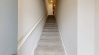 This contemporary 890 square foot apartment in Granger, IN offers a blend of comfort and style across two floors. The main level, comprising 740 square feet, showcases an open-concept design that seamlessly integrates the kitchen and living areas. The gourmet kitchen boasts sleek dark wood cabinetry, stainless steel appliances, granite countertops, and a convenient island, perfect for meal preparation and casual dining.

Large windows throughout flood the space with natural light, while the combination of warm wood-look flooring and plush carpeting adds texture and comfort. The spacious bedroom, measuring 160 square feet, features ample closet space and is complemented by two well-appointed bathrooms with modern fixtures and finishes.

A notable feature is the private balcony, offering an outdoor extension to the living space. The apartment's thoughtful design includes a staircase connecting both levels, with the lower floor providing an additional 150 square feet of living area. Located in a well-maintained community with ample parking, this apartment offers a perfect blend of modern amenities and comfortable living space.