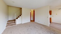 Located at 4400 45th Ave N in Robbinsdale, Minnesota, this two-story, two-bedroom, two-bathroom unit offers a practical and functional layout spread across two floors. The main level houses the living room, which features wall-to-wall carpeting, a sliding glass door opening to a private balcony, a wall-mounted air conditioning unit, and baseboard heating. Natural light filters in through vertical blinds, creating a bright and open atmosphere. The combined dining and kitchen area on the main floor is equipped with warm oak cabinetry, a double stainless steel sink, laminate flooring, and white appliances including a refrigerator and range. A staircase connects the main level to the upper floor, where both bedrooms are located. Each bedroom features soft carpeting, baseboard heating, and ample natural light from windows with vertical blinds. The primary bedroom is generously sized and includes its own closet, while the second bedroom also benefits from dedicated closet space. In total, the unit offers four closets for storage. The two bathrooms include tiled tub/shower combinations and mosaic tile flooring, with accessibility features such as grab bars present in one bathroom. Hallways on both floors provide smooth circulation throughout the unit.
