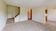 Located at 4400 45th Ave N in Robbinsdale, Minnesota, this two-story, two-bedroom, two-bathroom unit offers a practical and functional layout spread across two floors. The main level houses the living room, which features wall-to-wall carpeting, a sliding glass door opening to a private balcony, a wall-mounted air conditioning unit, and baseboard heating. Natural light filters in through vertical blinds, creating a bright and open atmosphere. The combined dining and kitchen area on the main floor is equipped with warm oak cabinetry, a double stainless steel sink, laminate flooring, and white appliances including a refrigerator and range. A staircase connects the main level to the upper floor, where both bedrooms are located. Each bedroom features soft carpeting, baseboard heating, and ample natural light from windows with vertical blinds. The primary bedroom is generously sized and includes its own closet, while the second bedroom also benefits from dedicated closet space. In total, the unit offers four closets for storage. The two bathrooms include tiled tub/shower combinations and mosaic tile flooring, with accessibility features such as grab bars present in one bathroom. Hallways on both floors provide smooth circulation throughout the unit.