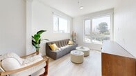 Located at 355 Glendale Blvd in the vibrant Echo Park neighborhood of Los Angeles, this modern 2-bedroom, 3-bathroom residence offers a well-designed single-floor layout with a clean, contemporary aesthetic throughout. Light wood flooring flows seamlessly across the living, dining, and bedroom areas, contributing to a bright and cohesive interior atmosphere.

The living room is generously lit by large windows on two walls, inviting abundant natural light and offering elevated views of the surrounding Los Angeles cityscape and tree-lined streets. The dining room continues this theme with floor-to-ceiling windows framing expansive outdoor views, creating an airy and inviting space ideal for gatherings.

The open dining and living area includes a convenient in-unit stacked washer and dryer, adding practical functionality to the stylish layout. The bedrooms are calm and minimalist, featuring light-toned walls, light wood floors, and built-in closet storage with integrated shelving and drawers. Views of the Los Angeles skyline are visible from the bedroom windows.

All three bathrooms reflect a cohesive modern design, featuring white subway tile walls, hexagonal tile flooring, floating vanities with white countertops, and matte black fixtures — combining clean lines with functional elegance. The overall ambiance of the residence is bright, modern, and thoughtfully designed.