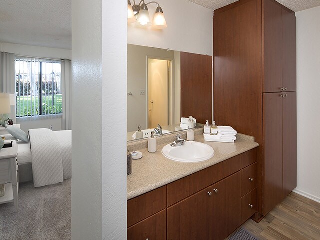 Baño del paquete clásico II con gabinetes de cerezo oscuro, encimera laminada beige y piso de superficie dura. - eaves South Coast