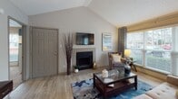 Located at 2900 Perimeter Pkwy in Augusta, Georgia, this single-floor residence offers a thoughtfully designed layout that balances comfort and functionality. The living room serves as the heart of the home, highlighted by a striking vaulted ceiling that enhances the sense of openness. A tiled fireplace anchors the space, while large windows fitted with blinds and patterned drapes allow generous natural light to pour in, offering pleasant outdoor views. Light-toned hardwood-style flooring runs throughout the living and dining areas, creating a warm and cohesive feel. The dining area features its own access door and additional windows, further connecting the interior to the surrounding environment. The kitchen is integrated into the open-concept layout, providing a seamless flow between living and dining spaces. Both bedrooms are carpeted for comfort and include ceiling fans, ample natural light from oversized windows, and access to walk-in or reach-in closets. The primary bedroom features a spacious walk-in closet visible through mirrored sliding doors. Each of the two bathrooms is equipped with a tiled tub-shower combination, granite-style shelving, and classic white tile surrounds. The overall aesthetic is neutral and inviting, with warm taupe walls and consistent finishes throughout.