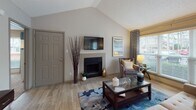 Located at 2900 Perimeter Pkwy in Augusta, Georgia, this single-floor residence offers a thoughtfully designed layout that balances comfort and functionality. The living room serves as the heart of the home, highlighted by a striking vaulted ceiling that enhances the sense of openness. A tiled fireplace anchors the space, while large windows fitted with blinds and patterned drapes allow generous natural light to pour in, offering pleasant outdoor views. Light-toned hardwood-style flooring runs throughout the living and dining areas, creating a warm and cohesive feel. The dining area features its own access door and additional windows, further connecting the interior to the surrounding environment. The kitchen is integrated into the open-concept layout, providing a seamless flow between living and dining spaces. Both bedrooms are carpeted for comfort and include ceiling fans, ample natural light from oversized windows, and access to walk-in or reach-in closets. The primary bedroom features a spacious walk-in closet visible through mirrored sliding doors. Each of the two bathrooms is equipped with a tiled tub-shower combination, granite-style shelving, and classic white tile surrounds. The overall aesthetic is neutral and inviting, with warm taupe walls and consistent finishes throughout.