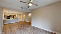 Located at 888 E 66th St in Indianapolis, Indiana, this well-designed single-floor residence offers four bedrooms and two bathrooms across a efficiently laid-out floor plan. The open-concept living and kitchen area serves as the heart of the home, featuring durable wood-look plank flooring, neutral warm-toned walls, and a ceiling fan that enhances airflow throughout the space. Large sliding glass doors lead to a private balcony, filling the living area with generous natural light and offering pleasant outdoor views. The kitchen is appointed with dark wood cabinetry, stainless steel appliances including a refrigerator, a black range and microwave, and a spacious white quartz peninsula with an undermount sink and stylish pendant lighting — ideal for both meal prep and casual dining. The bedrooms are carpeted for comfort, each offering closet storage, with the primary bedroom featuring a walk-in closet outfitted with wire shelving. The bathrooms are finished with tile surround tub-shower combinations and granite-topped vanities. A dedicated in-unit laundry room houses a full-size washer and dryer with additional wire shelving above. Clean finishes, functional storage, and a cohesive neutral palette give this home a move-in-ready appeal.