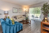 Located at 424 N Cedar Bluff Rd in Knoxville, Tennessee, this single-floor residence offers a well-designed layout with a comfortable blend of functional and inviting spaces throughout. The living room is generously sized, featuring wood-style plank flooring and a sliding glass door that opens to an outdoor patio, filling the space with natural light and providing a seamless indoor-outdoor connection. A separate dining area accommodates a full-sized dining set and is illuminated by track lighting overhead, with convenient closet storage nearby. The kitchen is outfitted with dark cabinetry, granite-style countertops, a stainless steel sink, and a dishwasher, offering ample storage and workspace. The bedrooms feature plush carpeting, large windows that bring in natural light, and built-in closets with louvered doors for organized storage. The bathroom includes a full tub-shower combination, a vanity with granite-style countertops, and classic fixtures. A dedicated laundry area houses a front-loading washer and dryer alongside an in-unit water heater and additional shelving. Throughout the residence, textured ceilings and neutral-toned walls create a clean, cohesive aesthetic well-suited for comfortable everyday living.