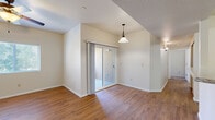 Located in El Paso, TX, this single-story, four-bedroom, two-bathroom home offers a practical and comfortable layout. The open living and dining area features warm hardwood-style flooring, vaulted ceiling details, a pendant light fixture, and a sliding glass door that brings in natural light and provides outdoor access. A ceiling fan adds to the comfort of the living space. The kitchen is well-appointed with rich dark wood cabinetry, light granite-style countertops, a gas range, built-in microwave, and a sink — offering ample storage and workspace for cooking. The four bedrooms are carpeted for comfort, each with natural light from windows and ceiling fans in select rooms. The primary bedroom includes a generous walk-in closet with built-in shelving and hanging rods. Both bathrooms feature dark wood vanities topped with light granite-style counters, oval mirrors, and hardwood-style flooring, with one bathroom offering a full tub/shower combo. A dedicated laundry area with shelving above rounds out the home's functional amenities. Clean neutral tones throughout create a bright, move-in ready atmosphere well-suited for everyday living.