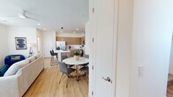 This well-appointed two-story residence showcases a contemporary design aesthetic defined by warm wood tones, crisp white walls, and light hardwood flooring that flows throughout the main living areas. The open-concept kitchen is a standout feature, outfitted with flat-front wood cabinetry, a herringbone tile backsplash, stainless steel appliances including a French door refrigerator, a built-in microwave, and a gas range. A central island with bar seating connects seamlessly to the dining area, where a round marble-top table anchors the space with understated elegance. The living room benefits from multiple windows that invite natural light, complemented by a ceiling fan and hardwood flooring. A dedicated office space provides a quiet, carpeted retreat with ample natural light through slatted blinds. The primary bathroom is generously proportioned, featuring a dual-sink vanity with wood cabinetry, a glass-enclosed shower, a separate water closet, and direct access to a walk-in closet with built-in shelving. Bedrooms are comfortable and well-lit, with windows overlooking the surroundings. A dedicated in-unit laundry room houses a full-sized top-load washer and dryer. Additional walk-in closet storage with multi-rail shelving and carpeted flooring adds to the functional appeal of this modern two-floor home.