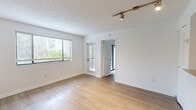 Located in Miami, FL, this well-appointed 1-bedroom, 2-bathroom residence offers a thoughtfully designed single-level layout. Light wood-style flooring runs throughout the home, creating a cohesive and clean aesthetic. The living room is bright and open, featuring large windows with horizontal blinds that invite natural light and offer views of surrounding greenery. Track lighting on the textured ceiling adds functional illumination to the space. A glass-paneled door provides access to an outdoor area, enhancing the airy feel of the living space. The kitchen is a standout feature, equipped with stainless steel appliances including a full-size refrigerator and electric range, white shaker-style cabinetry, granite countertops, and a classic white subway tile backsplash — combining style with practicality. The spacious primary bedroom connects to a dedicated bathroom and includes ample closet space. Both bathrooms are finished with clean, neutral tiling and include a tub-shower combination. A dedicated closet adds to the home's storage capacity. The consistent use of white walls and wood-tone flooring throughout gives the space a bright, modern, and inviting ambiance well-suited to Miami living.
