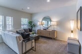 Located at The Chatham in Memphis, Tennessee, this single-story residence offers a well-designed two-bedroom, two-bathroom floor plan with a cohesive, neutral color palette that creates a calm and inviting atmosphere throughout.

The living room serves as the centerpiece of the home, featuring a generous layout with plush wall-to-wall carpeting, recessed lighting, and a bank of windows that flood the space with natural light and provide views of the surrounding greenery. The open sightlines from the entryway — accented by a wide-format art display wall — extend seamlessly into the living area, enhancing the sense of spaciousness.

The kitchen is well-appointed with an abundance of white cabinetry trimmed in warm wood tones, offering ample storage and counter space. White appliances, a double sink, and light hardwood-style flooring complete the functional and clean aesthetic. A window above the sink provides additional natural light.

Both bedrooms are comfortably sized, carpeted, and feature windows that bring in natural light. Each room offers a tranquil retreat with neutral walls suited for a variety of décor styles.

The two bathrooms are finished with wood-toned cabinetry, white countertops, and hardwood-style flooring. One bathroom includes a shower-tub combination, while the second features a more compact vanity layout — both maintaining a consistent, clean design throughout.