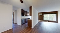 This single-floor, 4-bedroom, 1-bathroom unit offers a well-designed layout that balances open communal spaces with comfortable private quarters. The open-concept living and dining area is highlighted by rich hardwood-style flooring, a textured ceiling, and a ceiling fan with integrated lighting. A large sliding glass door floods the space with natural light and provides views of lush greenery beyond a private balcony, creating a bright and welcoming atmosphere.

The kitchen is thoughtfully appointed with dark espresso cabinetry, granite countertops, stainless steel appliances including a refrigerator, electric range, built-in microwave, and dishwasher, all set atop matching hardwood-style flooring. The galley-style layout maximizes efficiency and storage.

The four bedrooms are carpeted for comfort and feature diamond-pane windows that invite natural light while maintaining a cozy feel. The primary bedroom includes a walk-in closet with built-in shelving, offering generous storage. Additional hallways connect the rooms seamlessly throughout the unit.

The bathroom is clean and functional, featuring mosaic tile flooring, a full tub-shower combination, and a vanity with a granite countertop. Two hallways provide smooth circulation throughout the space, completing this practical and comfortable floor plan.