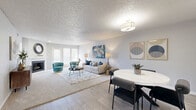This thoughtfully designed 2-bedroom, 2-bathroom single-floor home offers a comfortable and functional layout. The open-concept living and dining area serves as the heart of the home, featuring wood-look flooring, a textured ceiling, and large windows that allow natural light to pour in. A fireplace with a white mantle anchors the living room, creating a warm focal point. The dining area is highlighted by built-in shelving on either side and a pass-through window connecting to the kitchen, adding both style and practicality.

The kitchen is equipped with white cabinetry, a tile backsplash, stainless steel appliances including a dishwasher and refrigerator, and a bright window that enhances the sense of openness. A dedicated pantry area with open shelving provides additional storage.

The spacious primary bedroom features plush carpet, a ceiling fan, mirrored closet doors, and access to an in-unit washer and dryer. The second bedroom is bright and airy, benefiting from multiple windows with outdoor views and its own ceiling fan. Both bathrooms are clean and functional, with one featuring a full tub-shower combination with white tile surround and wood-look flooring. The home also includes a hallway and three closets, ensuring ample storage throughout.