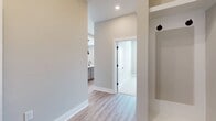 This charming single-story residence offers a compact yet comfortable living space of 860 square feet. The home features two bedrooms, including a primary bedroom of 150 square feet, and one bathroom. The heart of the home is an open-concept kitchen and living room area, creating a spacious feel and facilitating easy interaction between spaces.

Natural light floods the interior through large windows, brightening the rooms and creating an airy atmosphere. The windows are equipped with white blinds for privacy and light control. The flooring throughout is a warm, wood-look material that adds a touch of elegance and is easy to maintain.

The neutral-toned walls provide a blank canvas for personalization, while recessed lighting ensures even illumination throughout. The layout includes a hallway for easy navigation between rooms and a closet for additional storage. Despite its modest size, this home efficiently utilizes space to create a comfortable and inviting environment suitable for various lifestyles.