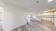 Located at 801 S German Ln in Conway, Arkansas, this single-story 2-bedroom, 1-bathroom home offers a well-designed layout with a clean, modern aesthetic. Light-toned wood-look flooring runs throughout the entire home, creating a cohesive and airy feel. The heart of the home is an open-concept living, dining, and kitchen area that flows seamlessly together. The kitchen is well-appointed with white shaker-style cabinetry, granite-look countertops, a peninsula with a sink, and white appliances including a range and refrigerator — all complemented by abundant cabinet storage. The living area features a ceiling fan and access to a private outdoor space through French doors that flood the room with natural light and offer pleasant outdoor views. The primary bedroom is a comfortable size with a ceiling fan and a large window bringing in natural light. The second bedroom is equally well-lit and offers access to closet storage. The full bathroom is neatly finished with a granite-topped vanity, a full tub-and-shower combination, and wood-look flooring. Additional practical spaces include a dedicated laundry area, a utility room, and multiple closets for ample storage throughout the home.