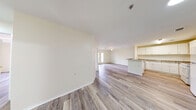 Located at 801 S German Ln in Conway, Arkansas, this single-story 2-bedroom, 1-bathroom home offers a well-designed layout with a clean, modern aesthetic. Light-toned wood-look flooring runs throughout the entire home, creating a cohesive and airy feel. The heart of the home is an open-concept living, dining, and kitchen area that flows seamlessly together. The kitchen is well-appointed with white shaker-style cabinetry, granite-look countertops, a peninsula with a sink, and white appliances including a range and refrigerator — all complemented by abundant cabinet storage. The living area features a ceiling fan and access to a private outdoor space through French doors that flood the room with natural light and offer pleasant outdoor views. The primary bedroom is a comfortable size with a ceiling fan and a large window bringing in natural light. The second bedroom is equally well-lit and offers access to closet storage. The full bathroom is neatly finished with a granite-topped vanity, a full tub-and-shower combination, and wood-look flooring. Additional practical spaces include a dedicated laundry area, a utility room, and multiple closets for ample storage throughout the home.